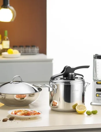 A collection of stainless steel kitchen utensils including spoons, ladles, whisks, and spatulas neatly arranged on a countertop.