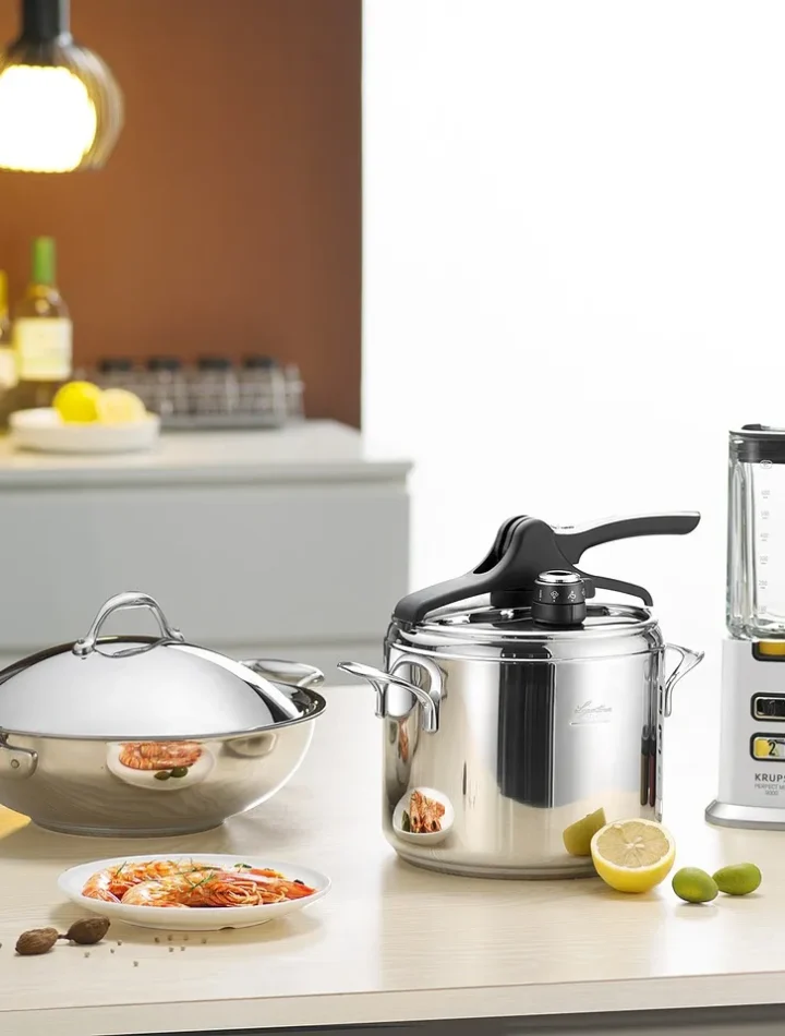 A collection of stainless steel kitchen utensils including spoons, ladles, whisks, and spatulas neatly arranged on a countertop.